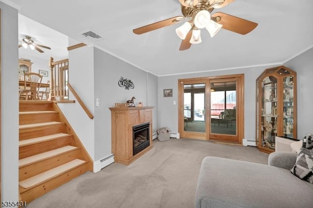 living area featuring ceiling fan, a baseboard radiator, light colored carpet, ornamental molding, and a glass covered fireplace