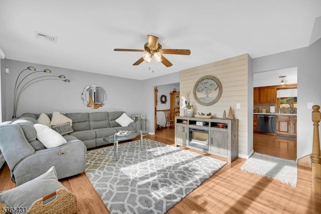 living area with ceiling fan and light wood-style flooring