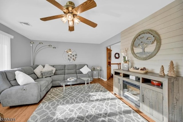 living area with wood finished floors, ceiling fan, and baseboards