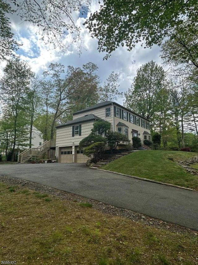 view of front of property with a front yard, a garage, and driveway