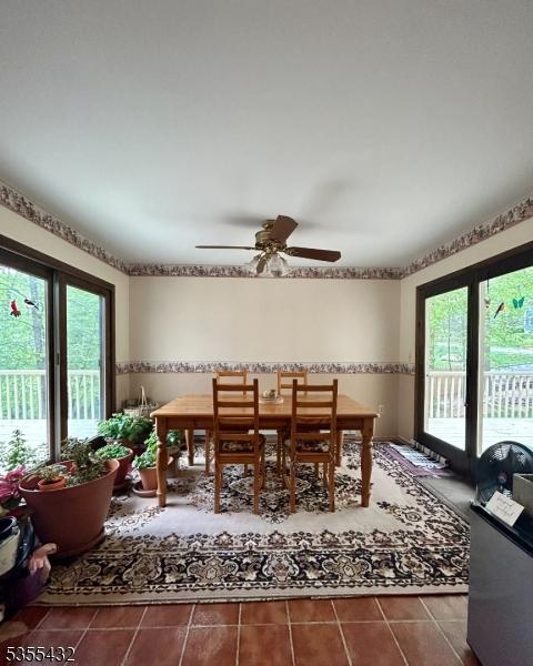 dining space with a ceiling fan, tile patterned flooring, and a healthy amount of sunlight