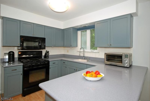 kitchen with black appliances, a sink, and backsplash