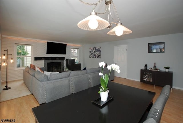 dining space featuring light wood-style flooring and a fireplace