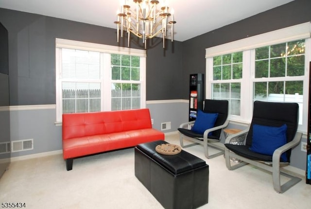 sitting room with a chandelier, baseboards, and carpet floors