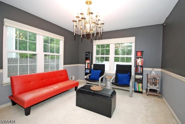 sitting room featuring a chandelier, carpet floors, and baseboards