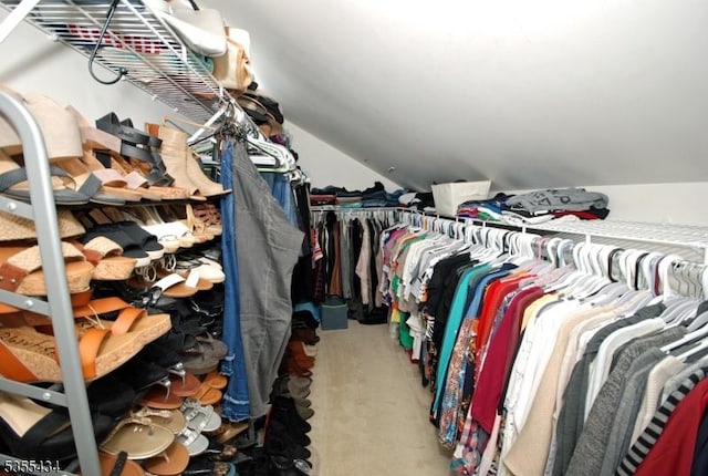 spacious closet featuring vaulted ceiling and carpet flooring