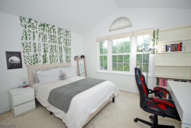 bedroom with vaulted ceiling, carpet flooring, and an office area