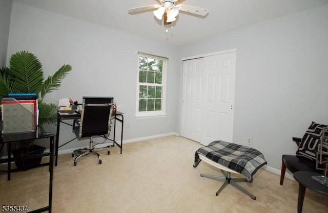 carpeted office featuring baseboards and a ceiling fan