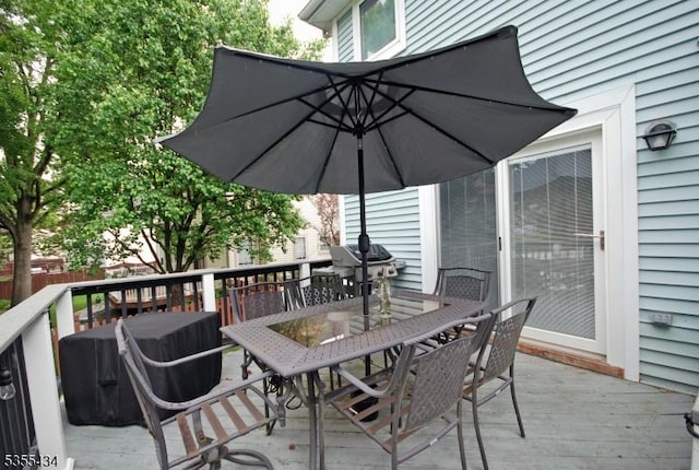 deck featuring outdoor dining space and a grill