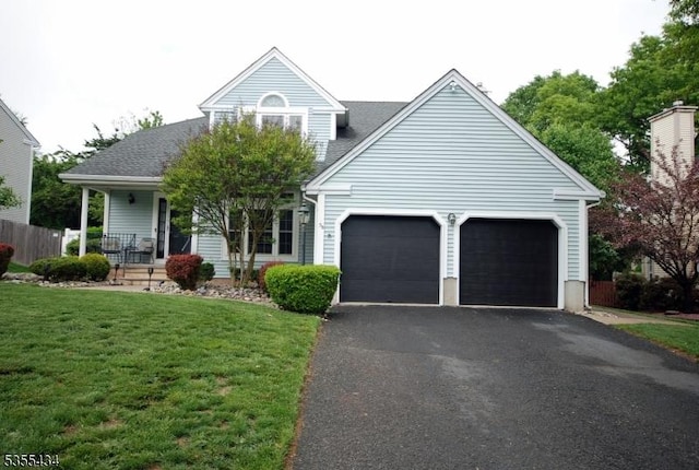 view of front of house featuring a garage, driveway, a front yard, and a porch
