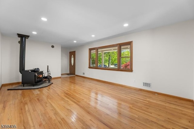 1296 Millstone River Rd, Hillsborough Twp, NJ 08844 - unfurnished living room with a wood stove, visible vents, light wood-style flooring, and baseboards