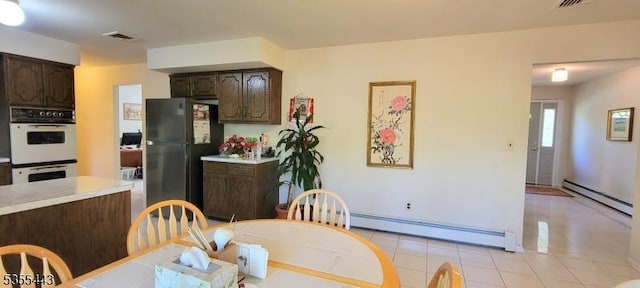 dining room featuring baseboard heating and light tile patterned flooring