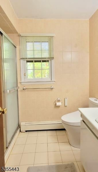 full bathroom featuring tile patterned floors, a baseboard heating unit, tile walls, toilet, and a stall shower