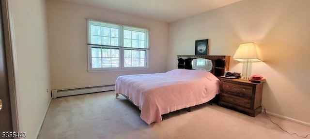 bedroom with baseboard heating, light colored carpet, and baseboards