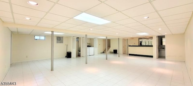 below grade area featuring recessed lighting, a drop ceiling, and washing machine and dryer