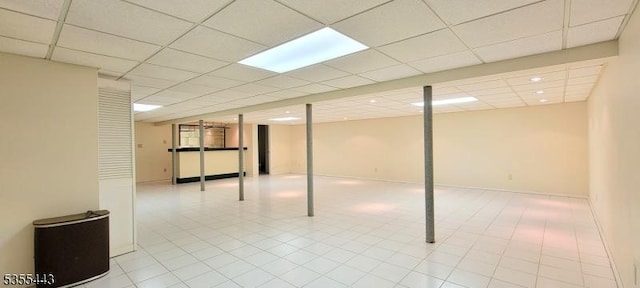 finished basement with a paneled ceiling, recessed lighting, and tile patterned flooring