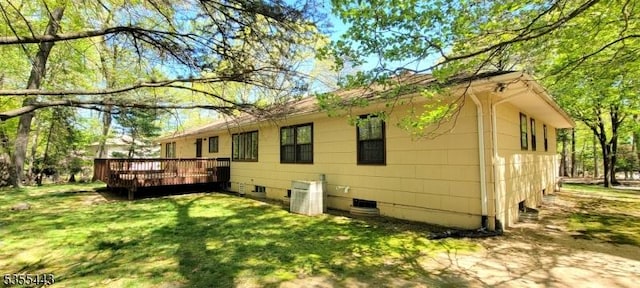back of property featuring a wooden deck and a yard