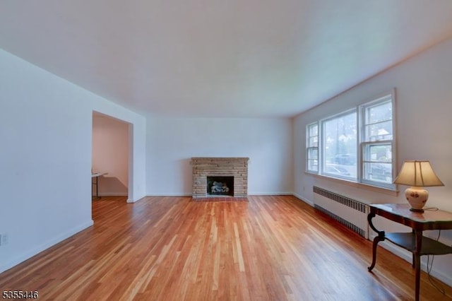377 Delaware Ave, Union Twp, NJ 07083 - unfurnished living room with radiator, light wood-style floors, and a fireplace