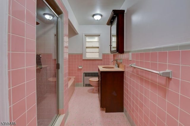 377 Delaware Ave, Union Twp, NJ 07083 - bathroom featuring vanity, a shower stall, tile walls, wainscoting, and radiator