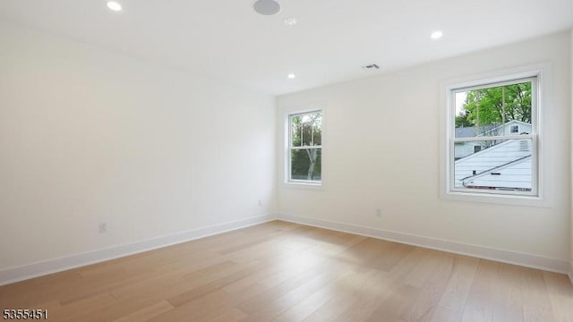 empty room featuring light wood-style flooring, baseboards, and recessed lighting