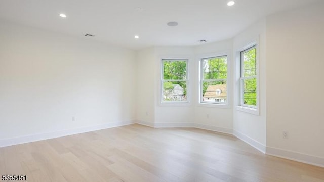 unfurnished room featuring light wood finished floors, recessed lighting, and baseboards