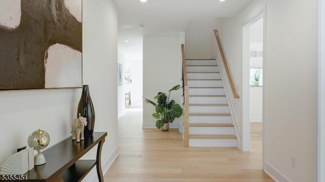 staircase with wood finished floors, recessed lighting, and baseboards