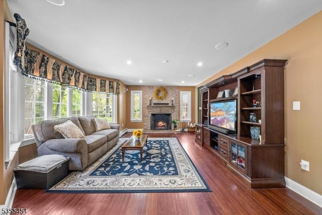 living room with baseboards, a fireplace, and wood finished floors