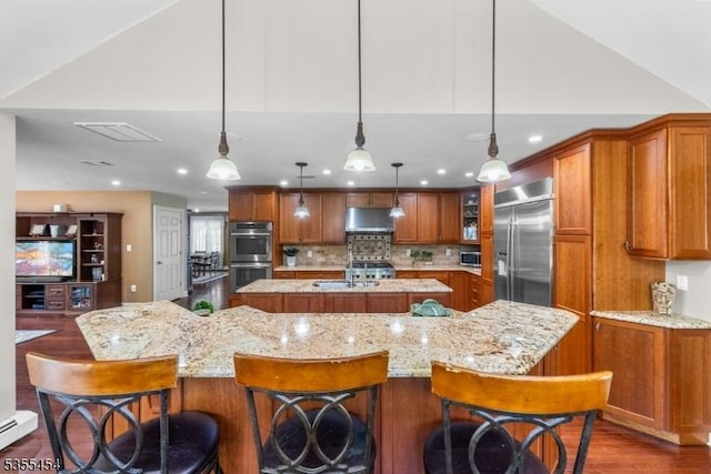 kitchen featuring brown cabinetry, a large island, and appliances with stainless steel finishes