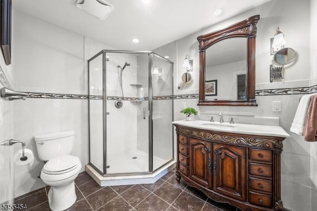 bathroom featuring tile walls, a stall shower, vanity, toilet, and recessed lighting