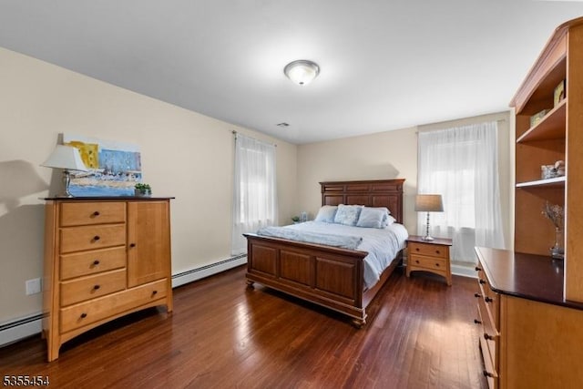 bedroom with dark wood-style flooring and baseboard heating