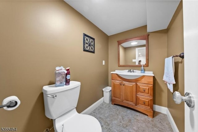 bathroom with toilet, baseboards, and vanity