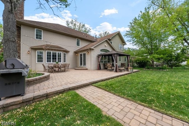 back of house featuring a yard, a gazebo, a chimney, and a patio area