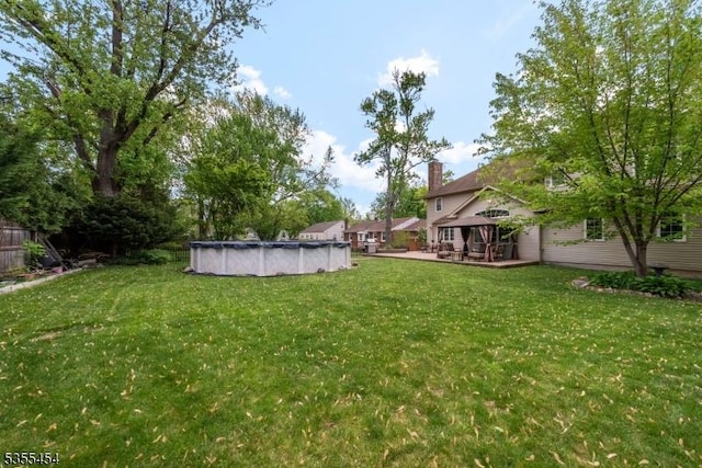 view of yard with a deck and a covered pool