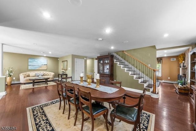 dining space featuring recessed lighting, baseboards, wood finished floors, a baseboard radiator, and stairway