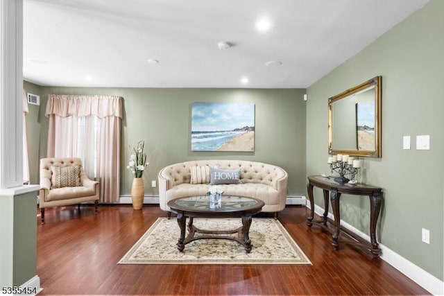 living area featuring baseboards, visible vents, baseboard heating, and wood finished floors