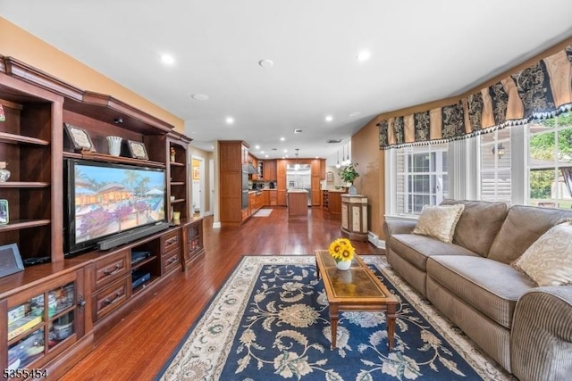 living area with dark wood-style flooring and recessed lighting