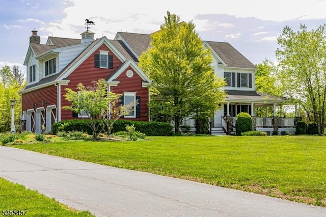 view of front of property with a porch, an attached garage, and a front lawn