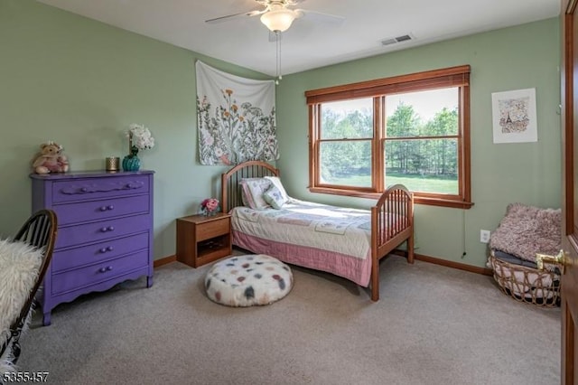 carpeted bedroom featuring baseboards, a ceiling fan, and visible vents