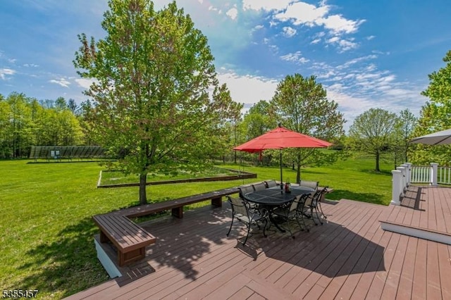 wooden terrace with a yard and outdoor dining space