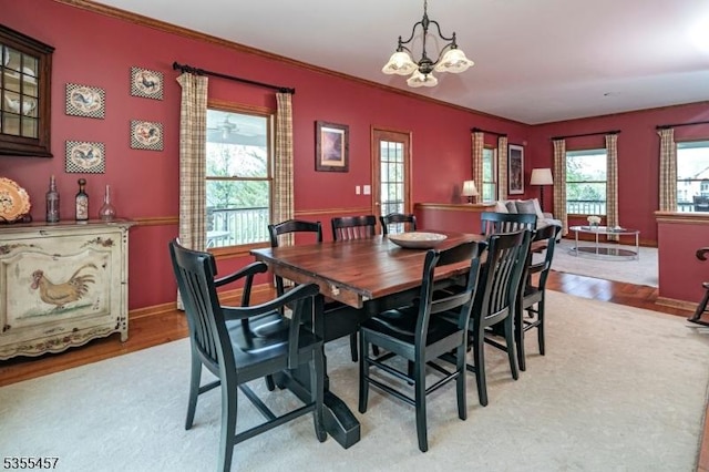 dining space featuring a chandelier, ornamental molding, baseboards, and light wood-type flooring