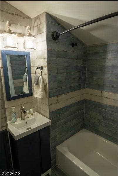 14 Luchetti Way, Andover Twp, NJ 07860 - full bathroom with vanity, lofted ceiling, tile walls, tasteful backsplash, and shower / washtub combination