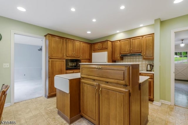 1178 Delaware Dr, Bridgewater Twp, NJ 08807 - kitchen featuring a center island, under cabinet range hood, black microwave, brown cabinetry, and recessed lighting