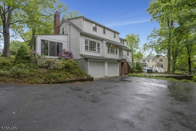 1178 Delaware Dr, Bridgewater Twp, NJ 08807 - view of front facade featuring a chimney, a garage, asphalt driveway, and stairs