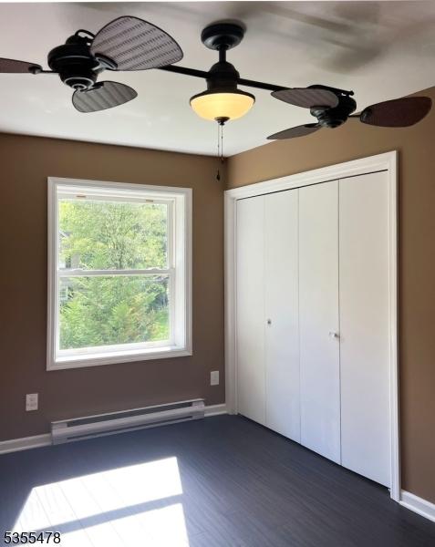 1 Lenape Ln, Harmony Twp, NJ 08865 - unfurnished bedroom featuring a baseboard radiator, dark wood-type flooring, baseboards, and a closet