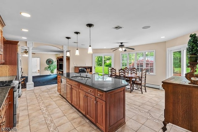 kitchen with stainless steel appliances, a sink, a ceiling fan, ornate columns, and brown cabinets