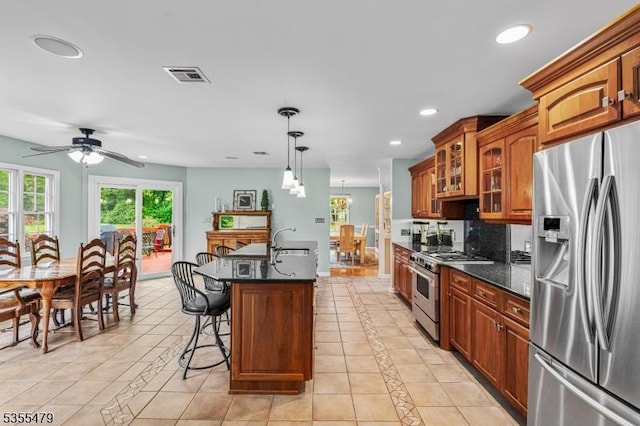 kitchen with stainless steel appliances, light tile patterned flooring, recessed lighting, glass insert cabinets, and a kitchen island with sink