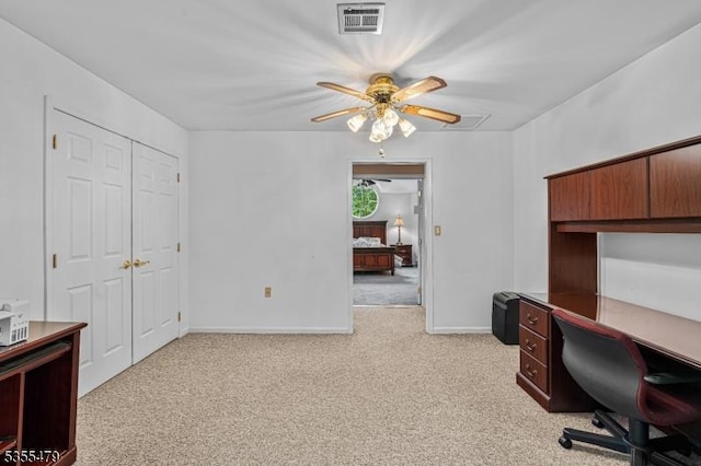 unfurnished office with a ceiling fan, light colored carpet, and baseboards