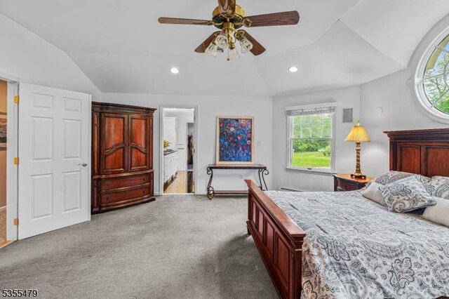 carpeted bedroom with vaulted ceiling, recessed lighting, ceiling fan, and ensuite bathroom