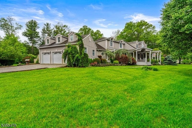 cape cod home featuring driveway, a front lawn, and covered porch