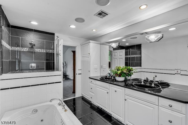 bathroom with recessed lighting, double vanity, a jetted tub, and tiled shower